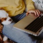 Woman on laptop with sleeping dog